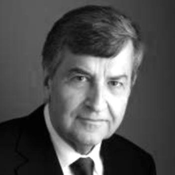 A black and white portrait of a man in a suit and tie, with short hair, looking directly at the camera against a plain background captures the timeless elegance suitable for an October event at Rockford Airport.