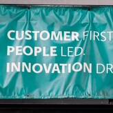 A teal banner features the UPS logo on the left, announcing: "CUSTOMER FIRST. PEOPLE LED. INNOVATION DRIVEN," setting the stage for 2024 UPS strides in service excellence.