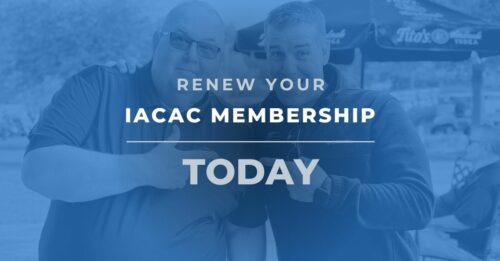 Two people stand side by side in Chicago, smiling and giving thumbs up. The text over the image reads, "Renew Your IACAC International Membership Today." The background is blurred with outdoor seating visible.